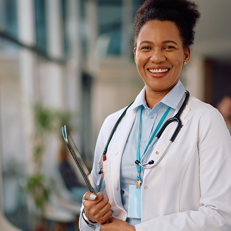 Clinician holding a tablet and smiling.
